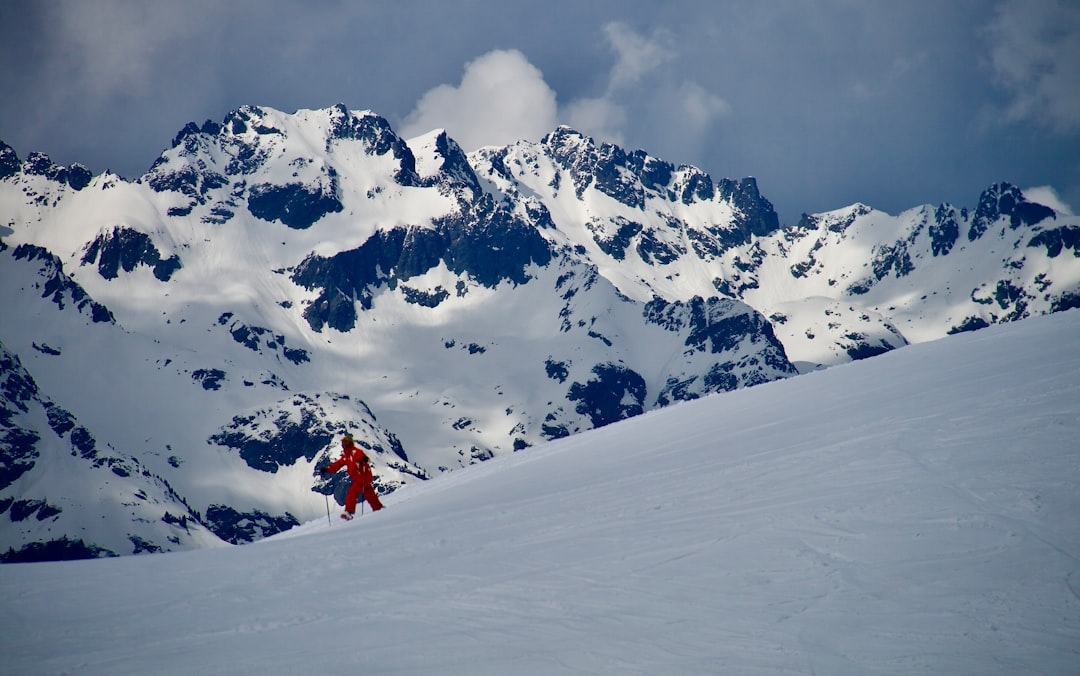 mikaela shiffrin 2026 olympics - Snowy mountain range with a person in orange
