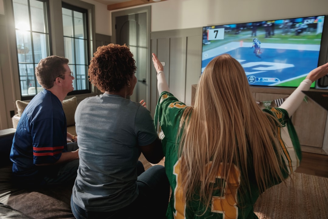 viral trends this week - Friends watching a sports game on television together at home.
