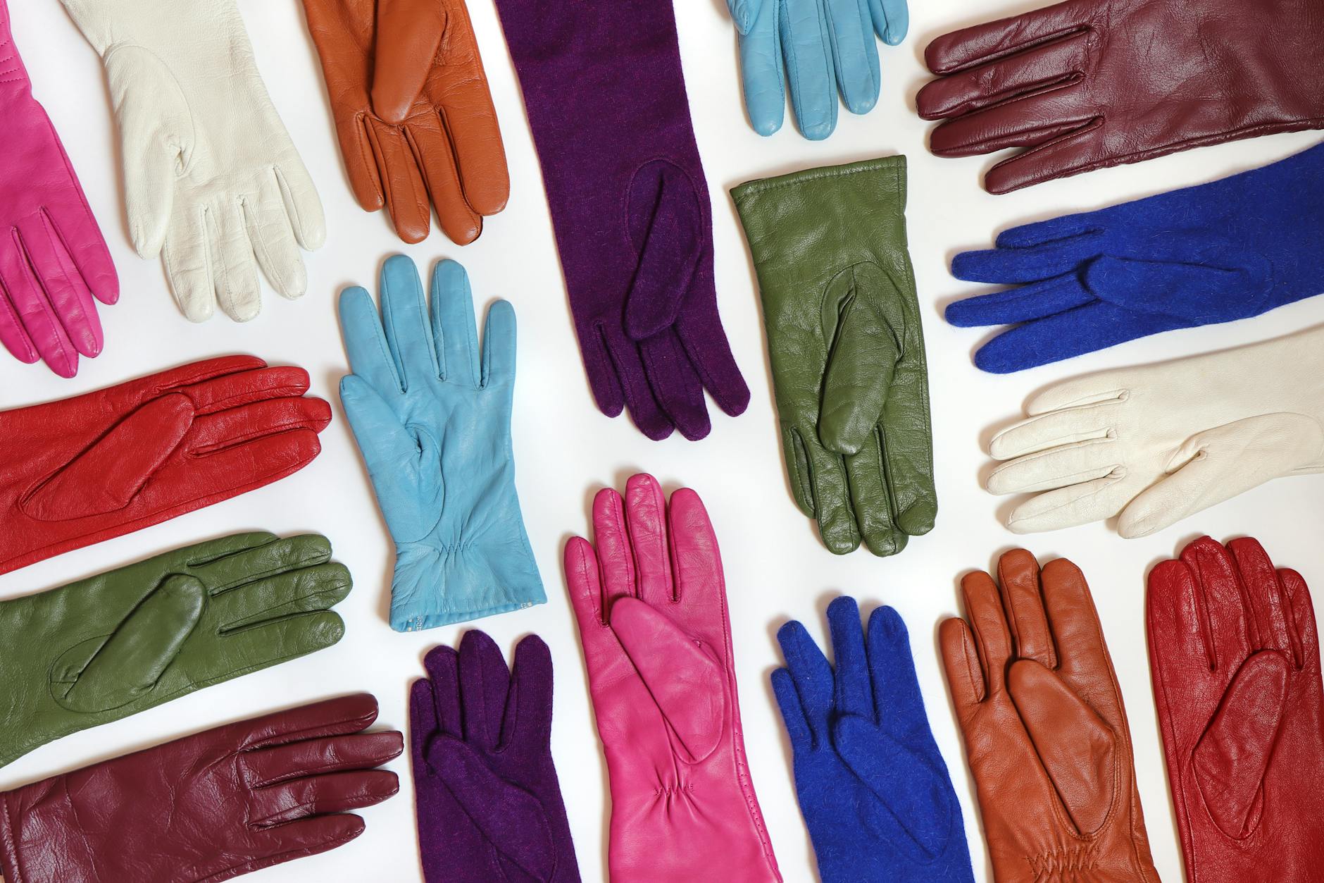 why dolly parton wears gloves - A vibrant collection of assorted leather gloves arranged in a flat lay pattern.