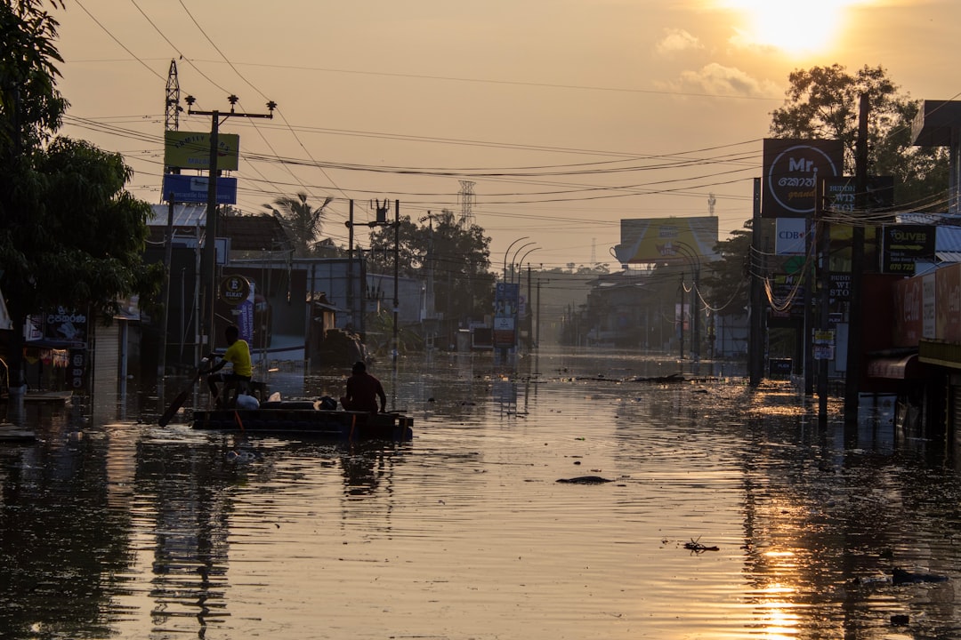 Traverse City flooding - People navigate a flooded street at sunset.