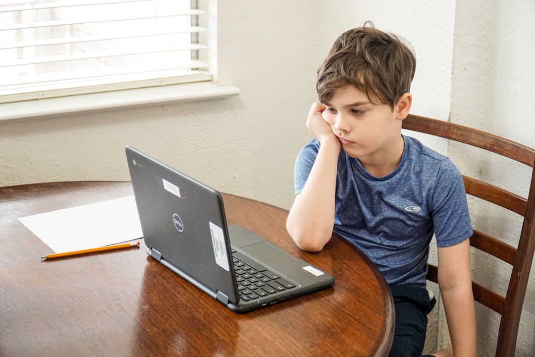 why is dadeschools portal not working - boy in blue crew neck t-shirt using macbook pro on brown wooden table